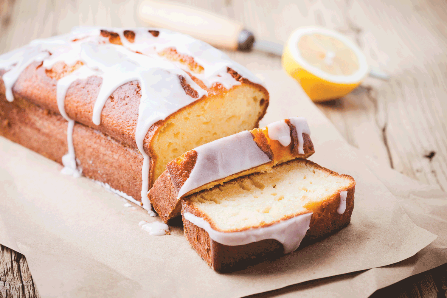 glazed lemon pound cake on rustic wooden table, sliced and ready to eat