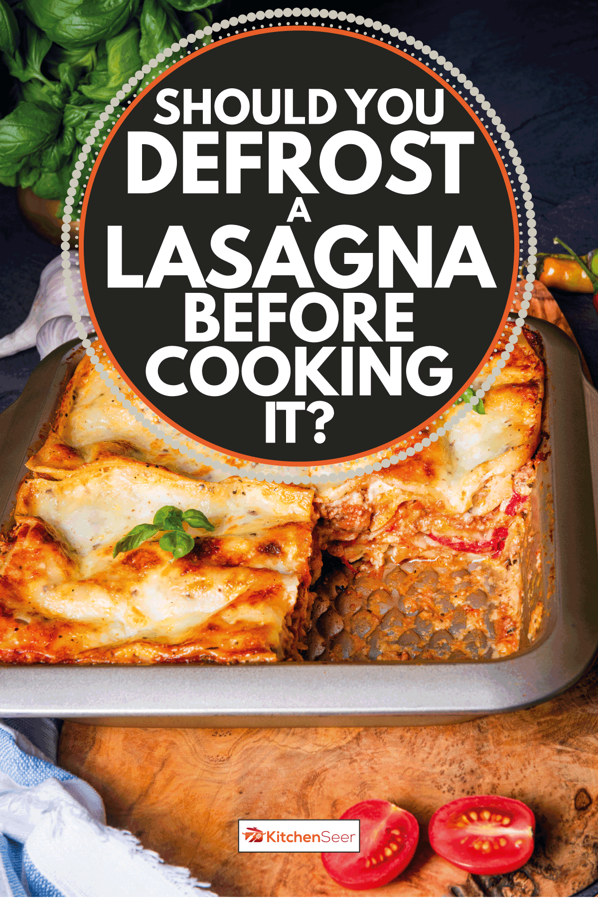 rustic spicy lasagna on a tin baking dish on top of a chopping board with basil. Should You Defrost a Lasagna Before Cooking it