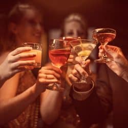 A man and four women are celebrating their success drinking a glass of wine and cocktail, How Many Wine And Cocktail Glasses Should You Have?