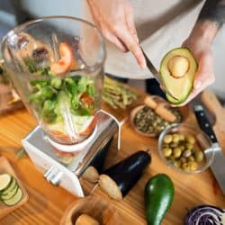 An unrecognizable man putting vegetables into blender, preparing healthy smoothie at his kitchen, Does A Blender Work As A Food Processor? [The Answer Might Surprise You!]