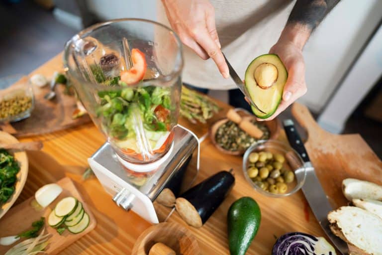 An unrecognizable man putting vegetables into blender, preparing healthy smoothie at his kitchen, Does A Blender Work As A Food Processor? [The Answer Might Surprise You!]