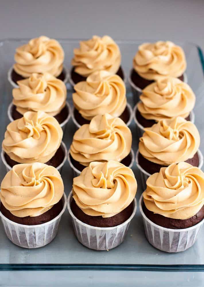 Chocolate cupcakes with peanut butter cream cheese frosting on glass tray