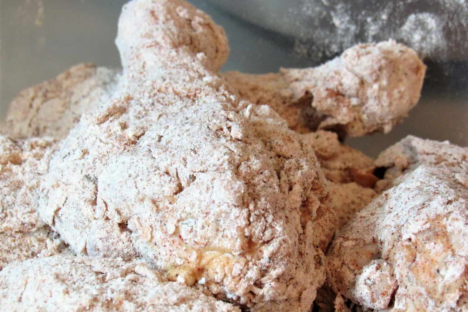 Close up shot of raw chicken drumsticks, floured and battered