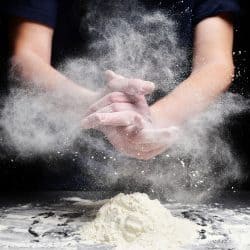 Cook slams splash hands with flour. White dust cloud of flour, Does Flour Brand Matter For Baking?
