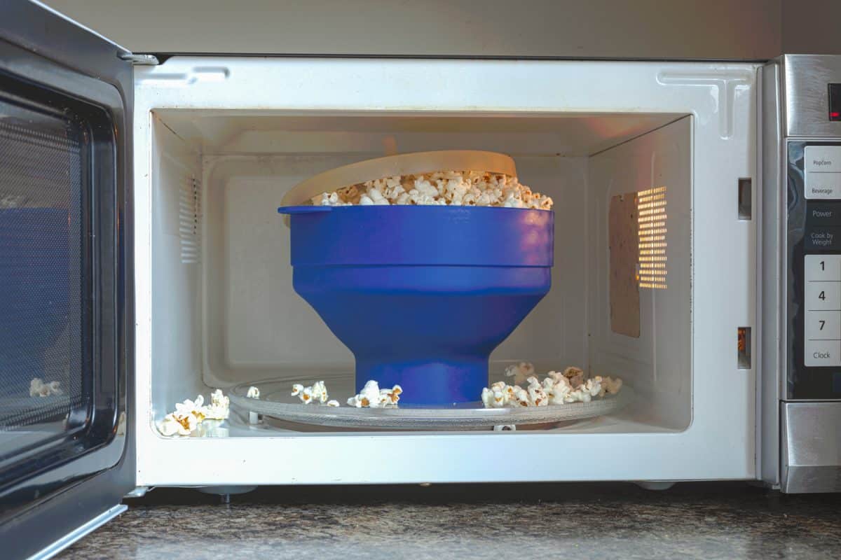 Homemade fat and salt free popcorns in a silicon BPA free collapsible popcorn popper bowl inside microwave. This bowl offers guilt free instant popcorns directly from kernels with no additives.