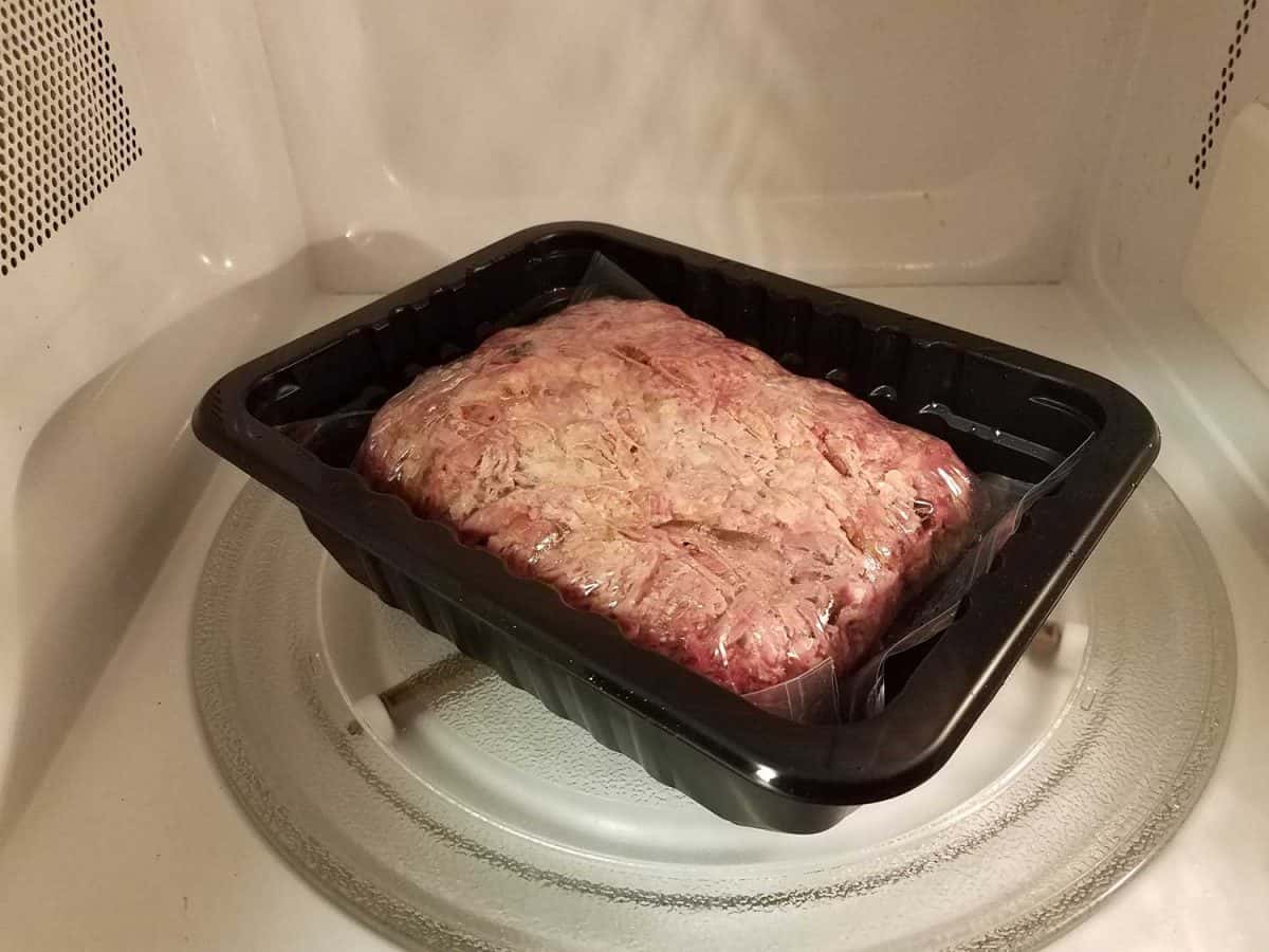 Pulled pork meat in plastic bag in microwave