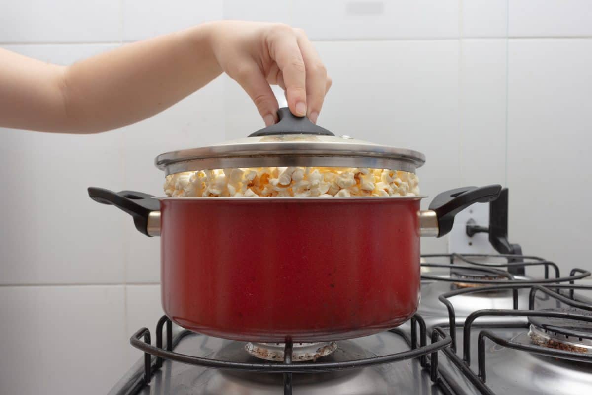 Red pan full of popcorn on the stove