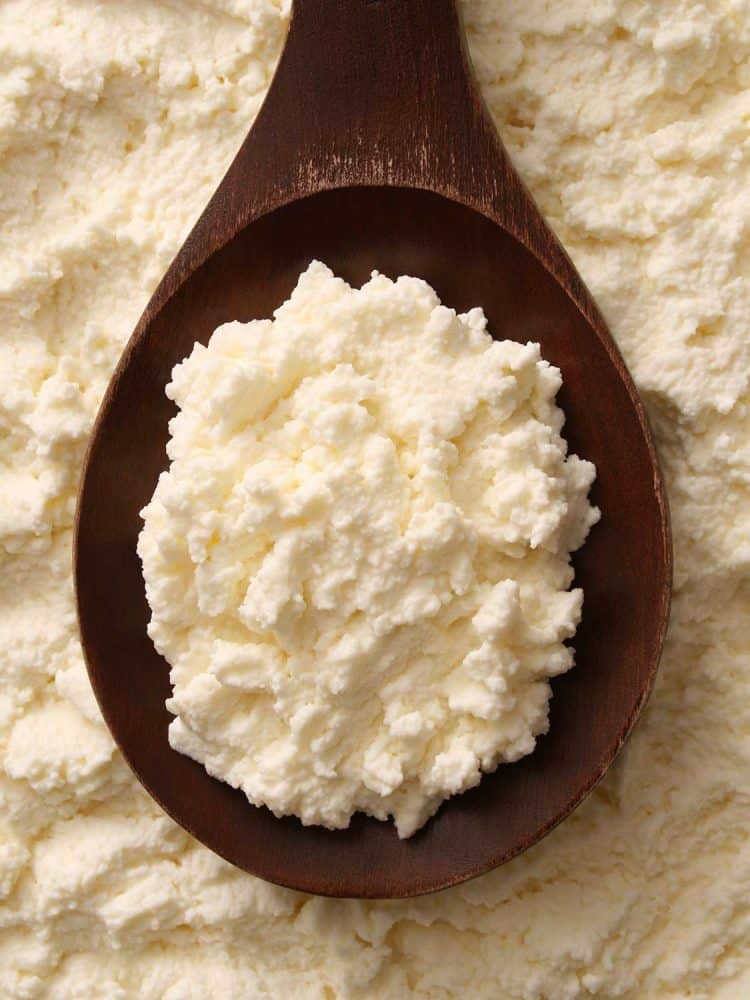Ricotta cheese spread over wooden spoon
