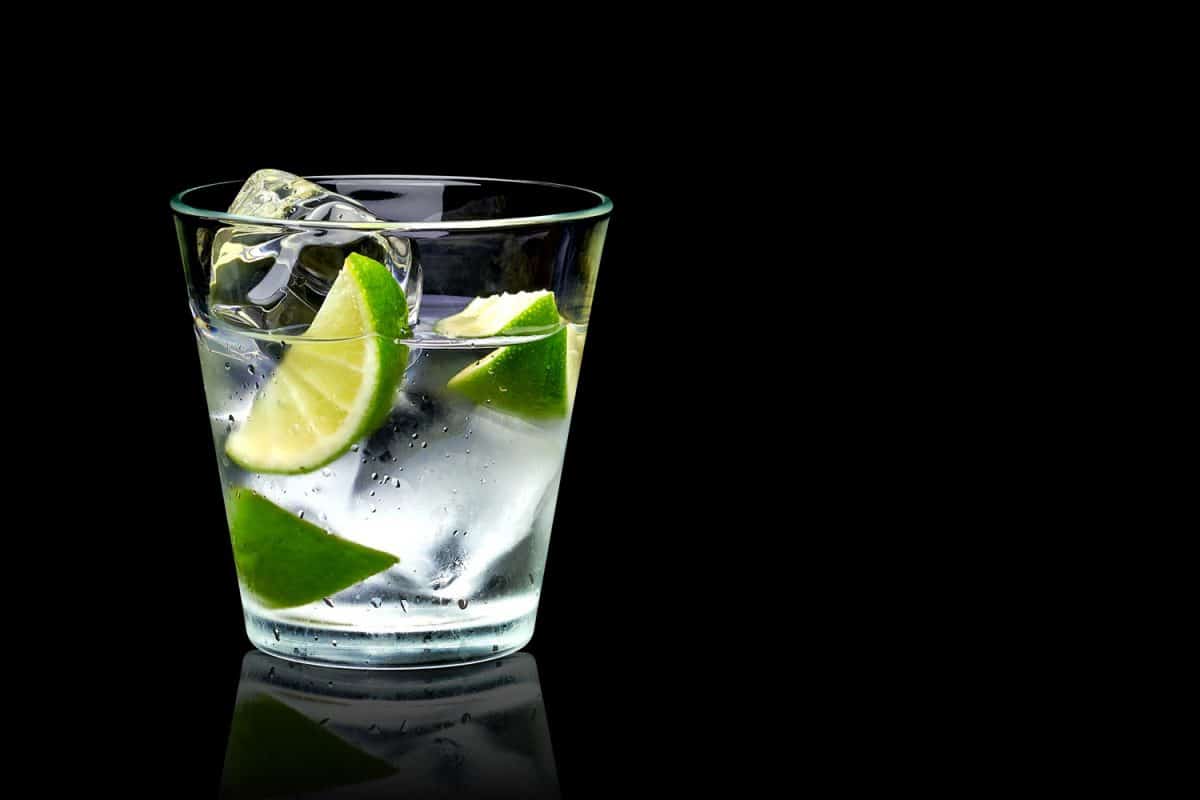 Vodka lime with ice in rocks glass on black background including clipping path