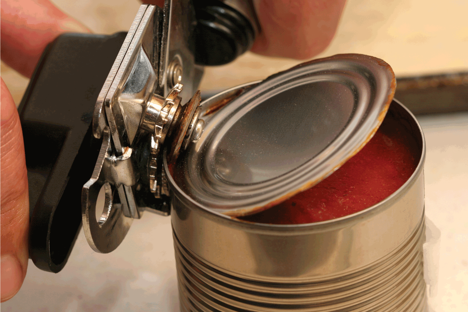 can opener opening can of tomato sauce
