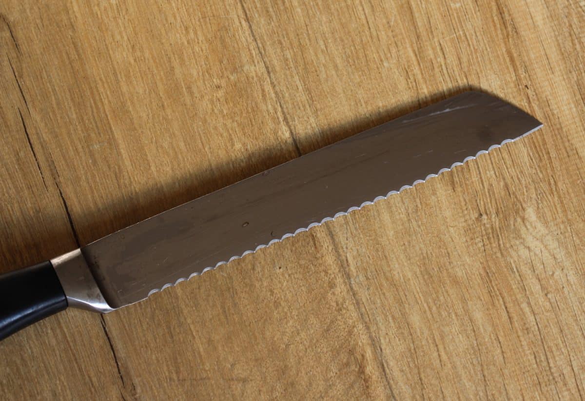 close up of bread knife on wooden table