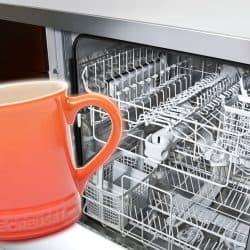 A Le Creuset mug and a dishwashing machine collage photo, Can Le Creuset Mugs Go In The Dishwasher?