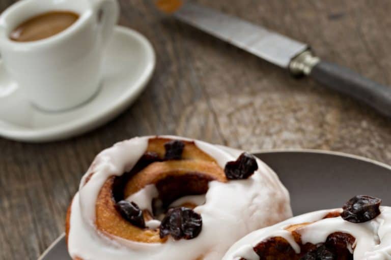 A close up shot of two cinnamon rolls and a small cup of coffee, What Goes With Cinnamon Rolls For Breakfast?
