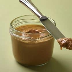 Almond butter in a jar and silver vintage knife with green background, Can Almond Butter Go Bad?