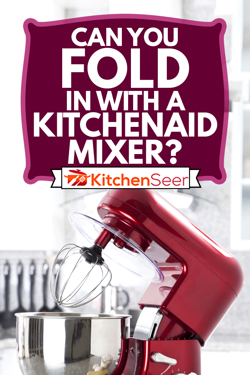 A red electric stand mixer on kitchen counter top with eggs, butter and flour as ingredients for making a pie in the foreground, Can You Fold In With A Kitchenaid Mixer?