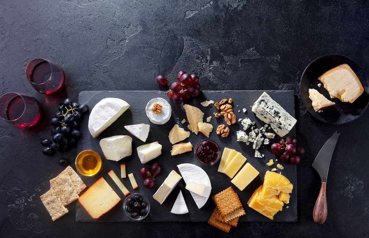 Cheese assortment on slate cutting board with wine