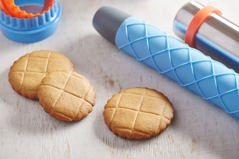 Cookies, embossing silicone rolling pin with checkered pattern and cookie cutters on a white wooden surface, Can You Put A Rolling Pin In The Dishwasher?