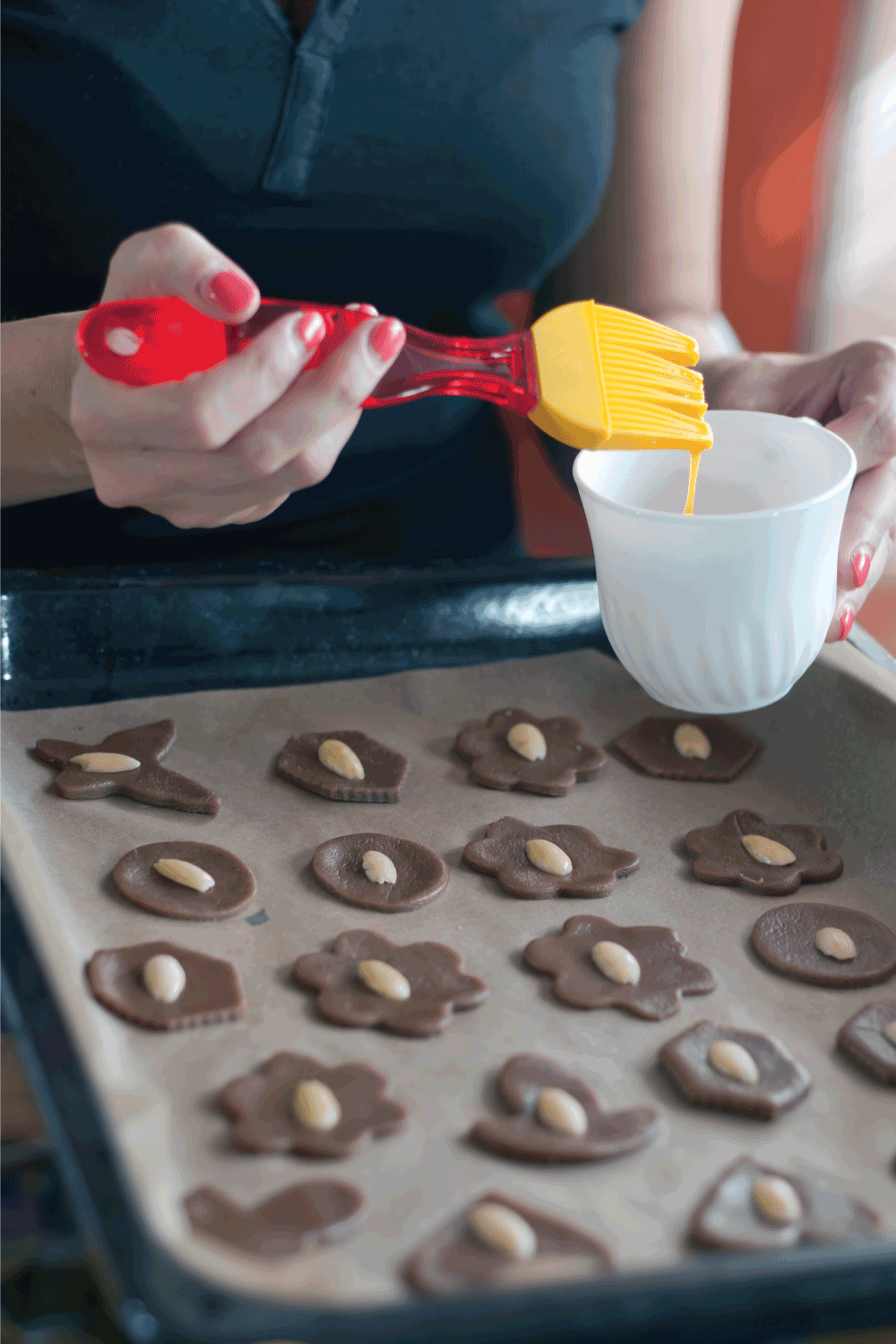 Glazing cookies on baking paper in a tray