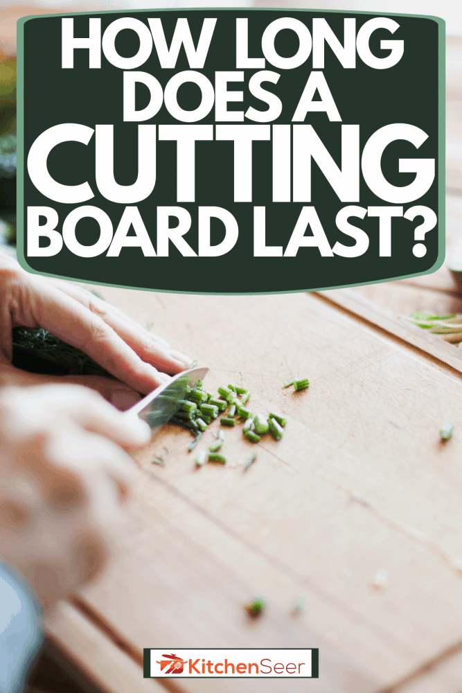 A woman chopping chives on her wooden chopping board, How Long Does A Cutting Board Last?
