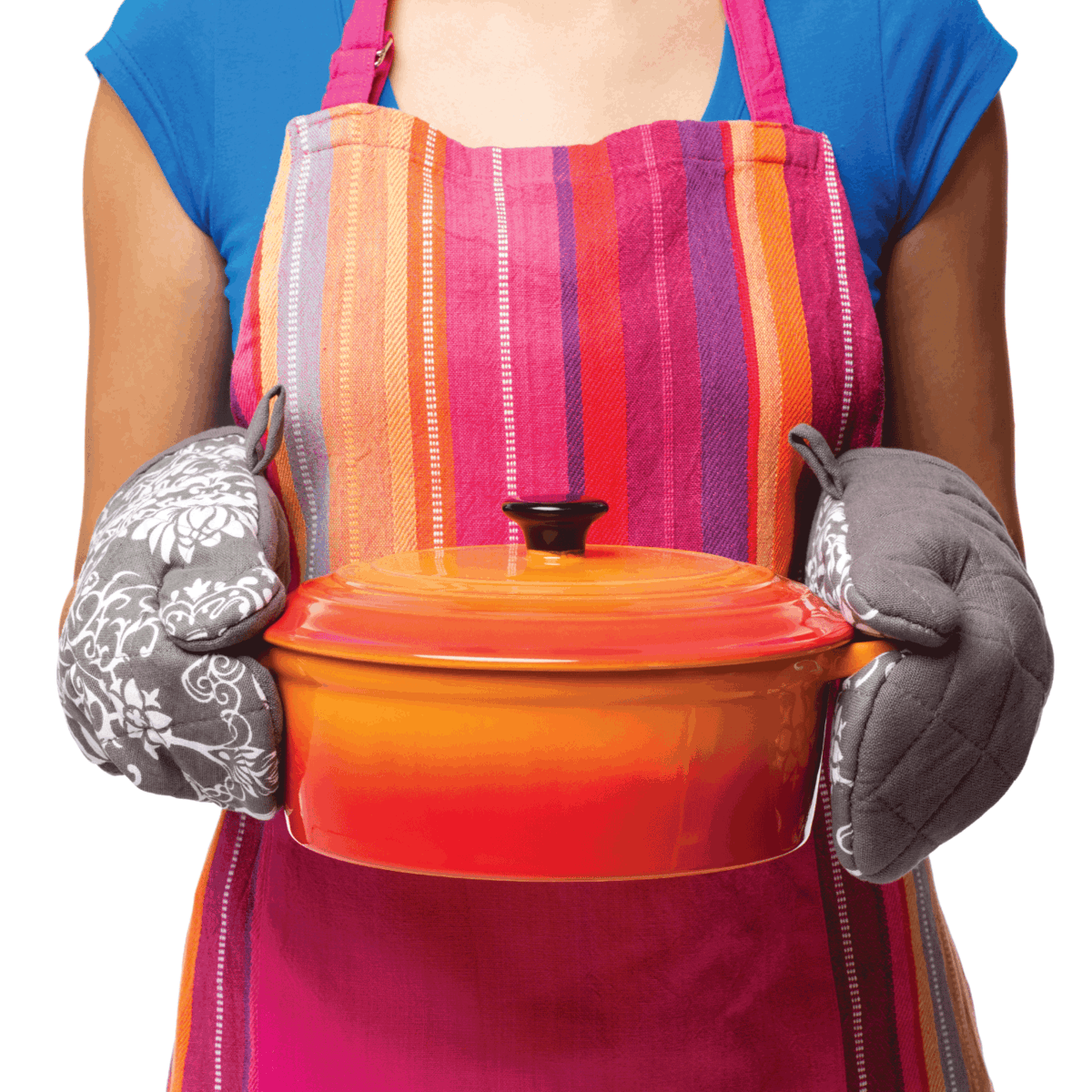 Midsection of woman in a multi colored apron holding a casserole