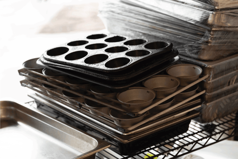 Muffin baking trays stacked in storage. How To Organize Baking Pans [7 Options To Consider]