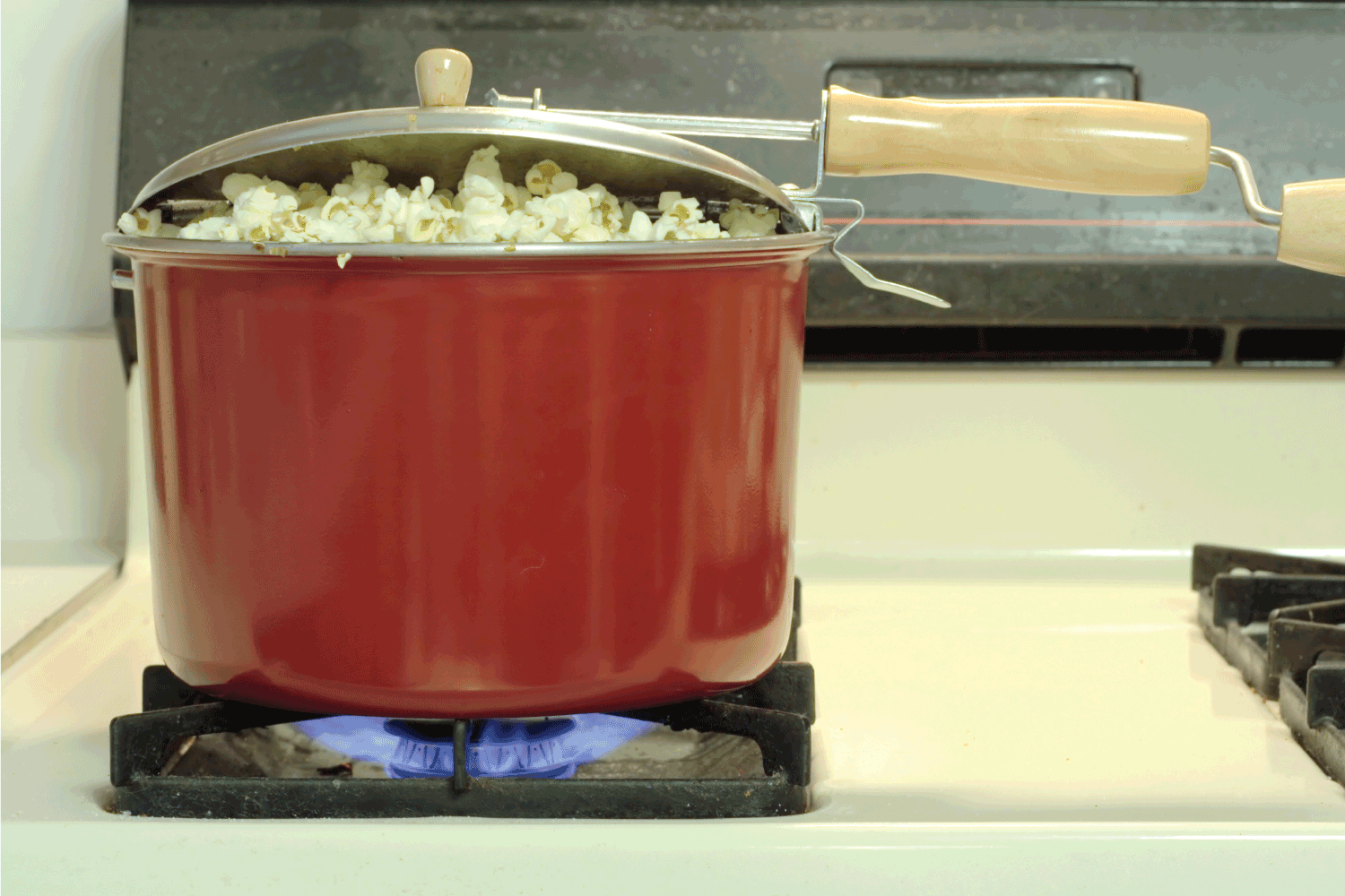 Popcorn on the stove cooking in a popcorn cooker