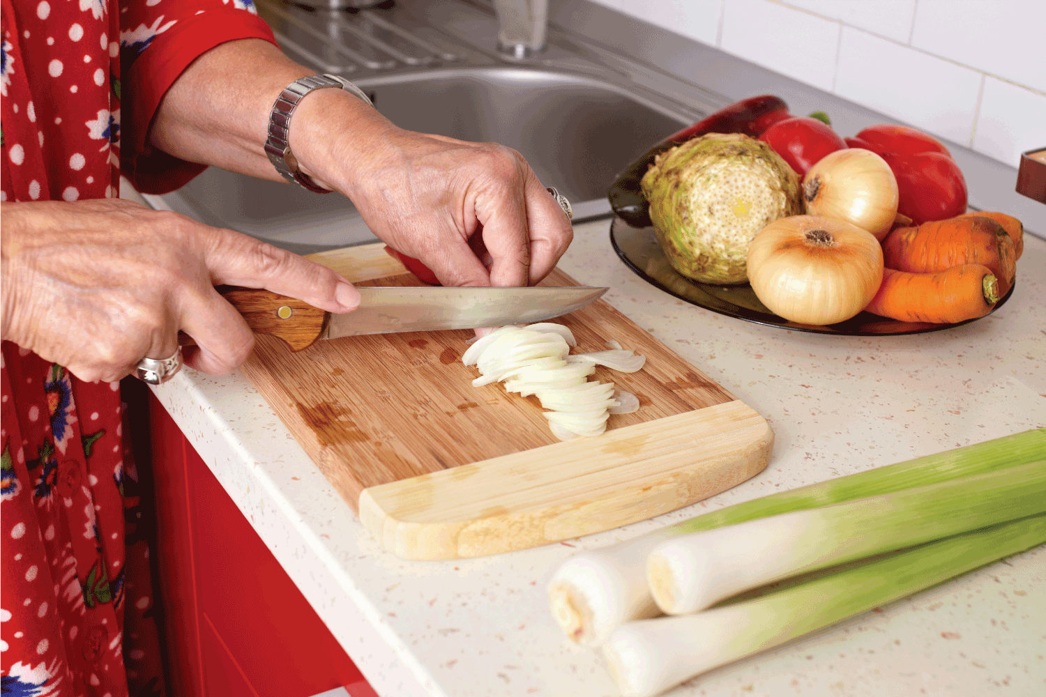 Senior woman's hands cutting vegetables