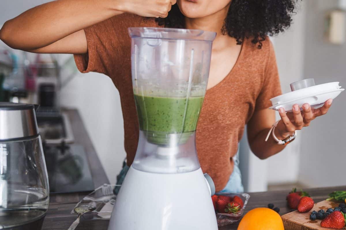 Shot of a young woman making a healthy smoothie at home