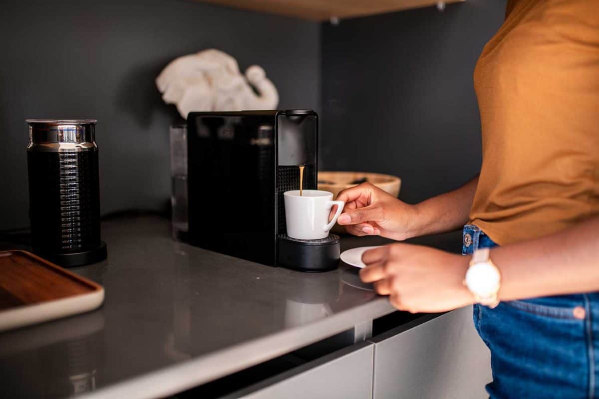 Woman having a fresh coffee with a coffee maker machine