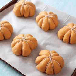 freshly prepared, homemade bread pumpkin designed rolls. Dough tied with string on grease proof paper, parchment lined baking tray. What Is A Cookie Sheet Used For