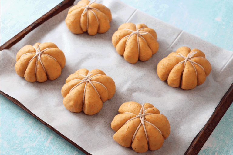 freshly prepared, homemade bread pumpkin designed rolls. Dough tied with string on grease proof paper, parchment lined baking tray. What Is A Cookie Sheet Used For
