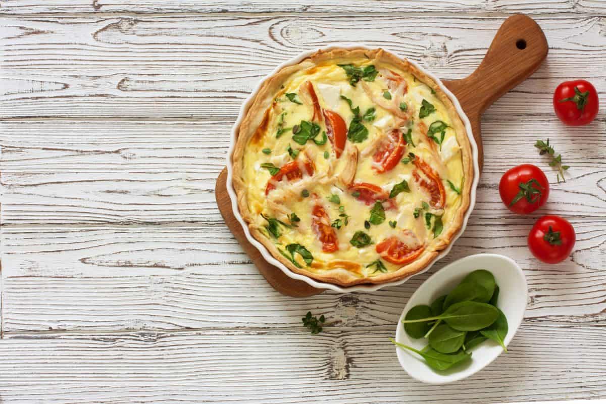 A delicious quiche with chicken, tomatoes, and spinach