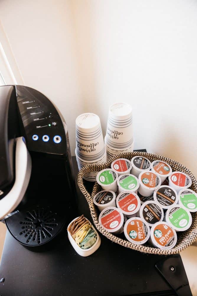 A Keurig coffee maker with coffee pods on a small tray basket