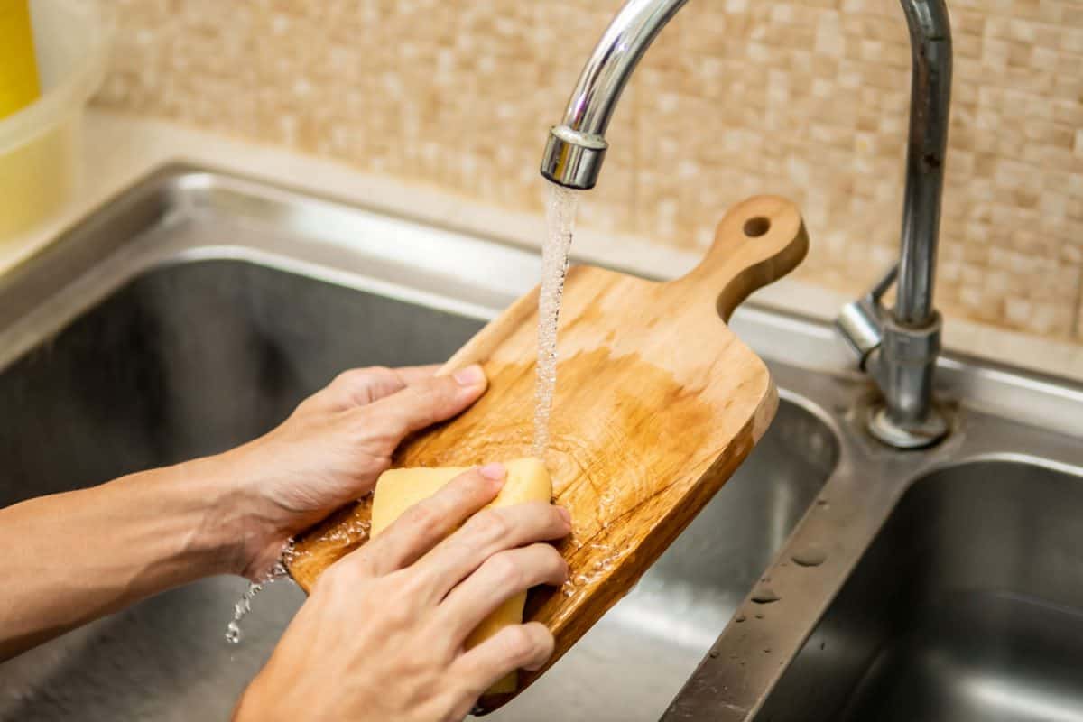 A woman washing her cutting board