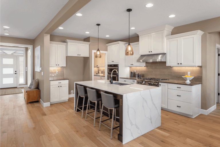 Beautiful kitchen in new home with island, pendant lights, and hardwood floors. Should Kitchen And Bathroom Floors Match