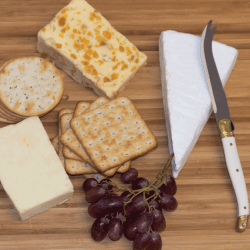 Cheese board with a variety of cheeses, crackers and red grapes. What Is The Hook On A Cheese Knife For
