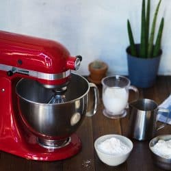 Closed standing kitchenaid mixer on wooden table with ingredients, How Long Can You Run A Kitchenaid Mixer?