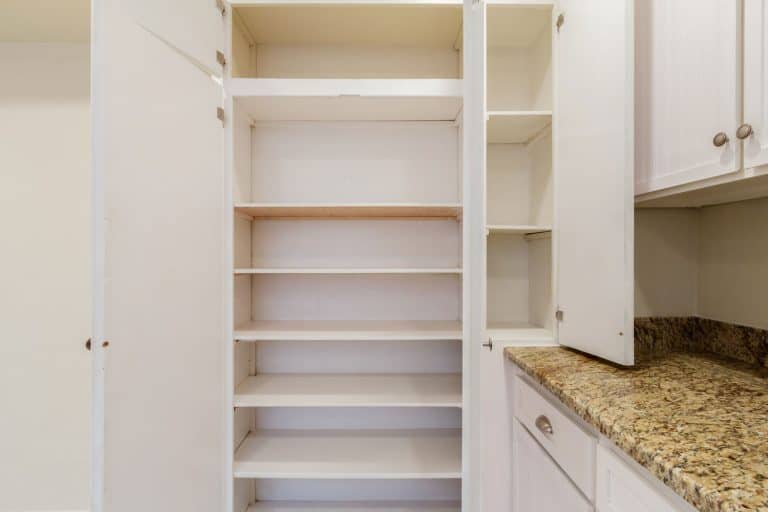 Empty pantry shelves next to a marble countertop kitchen , Can You Combine A Pantry And Laundry Room?