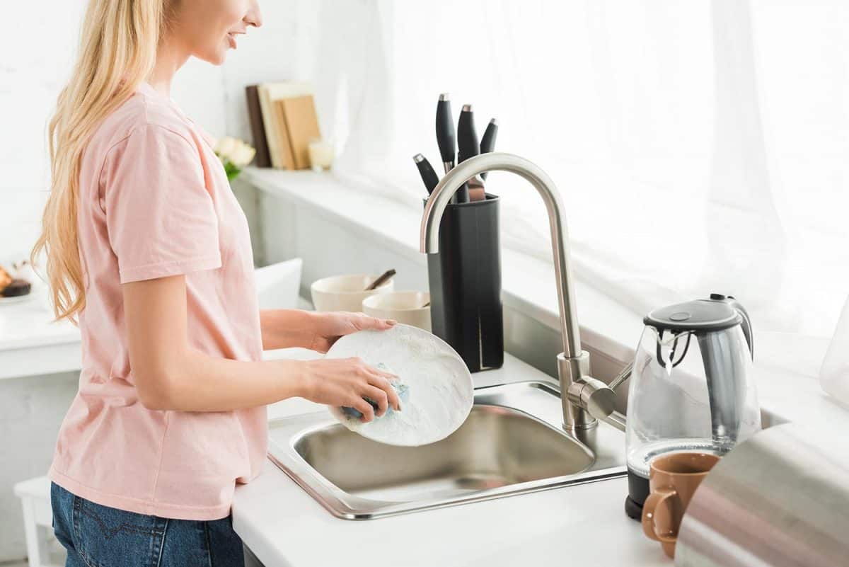 Woman washing dishes at kitchen