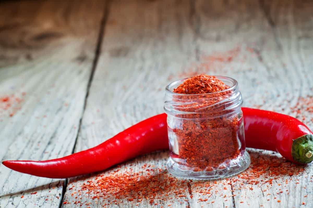 A small jar filled with cayenne pepper on the table
