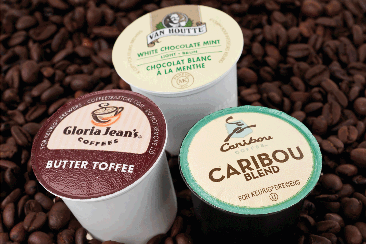 A variety of k-cups used for the Keurig single serve coffee maker placed on a bag of roasted coffee beans