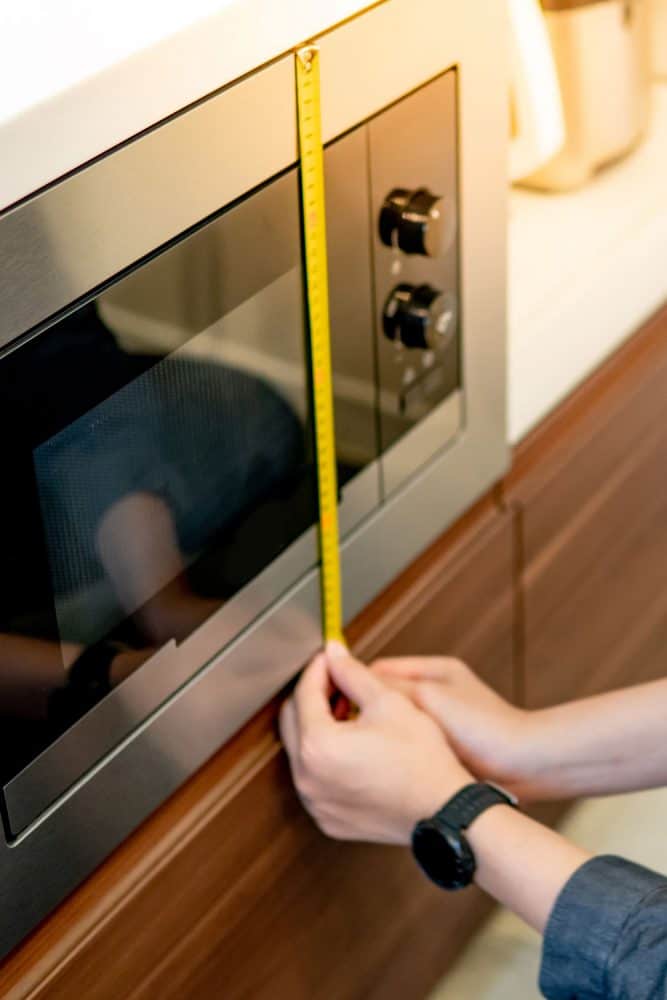 An Architect measuring the height of the microwave