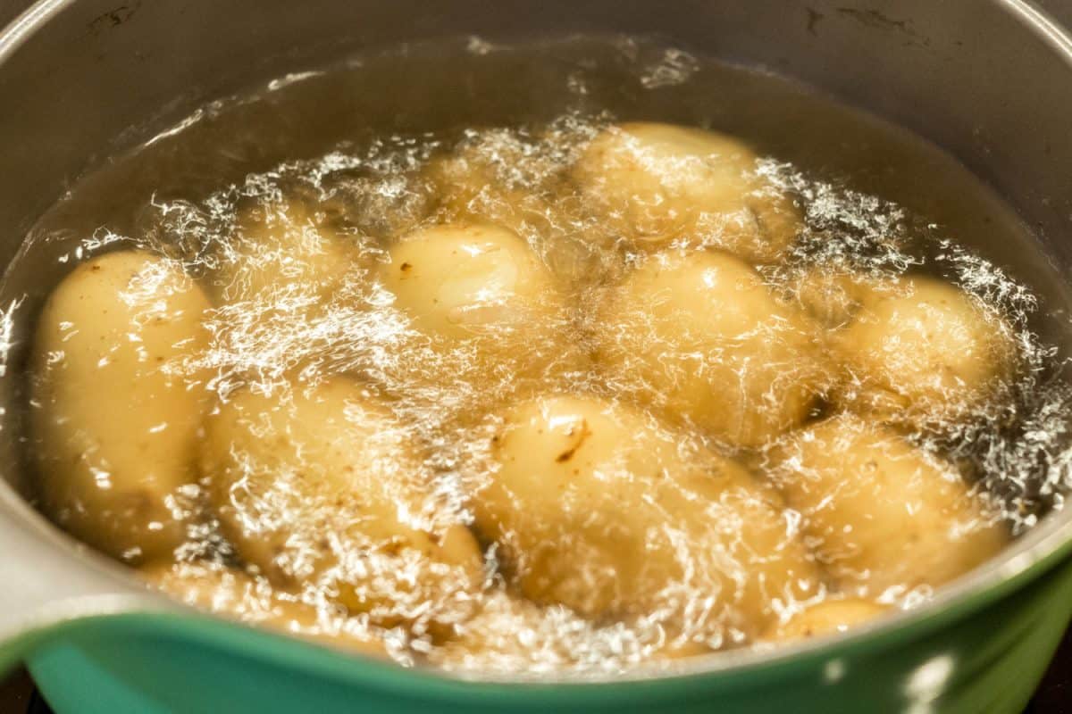 Boiling potatoes inside a green pot