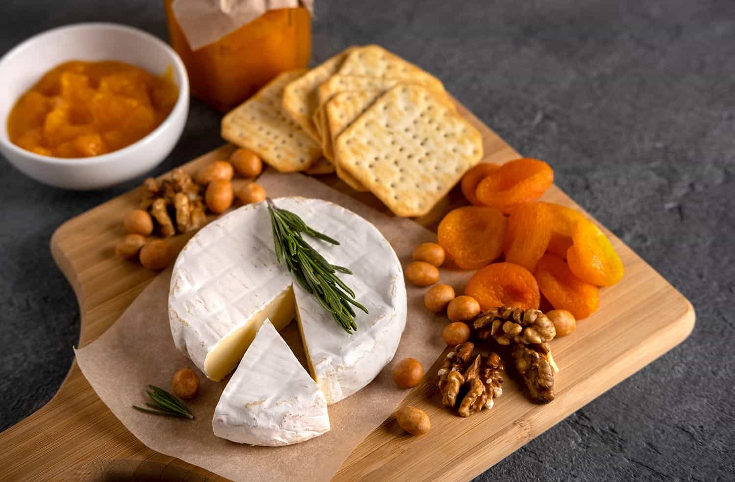 Brie cheese with nuts, pear slices and dried apricots