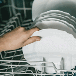Closeup female hand holding a plate into the kitchen organizer. How To Organize Deep Kitchen Drawers [3 Practical Ideas]
