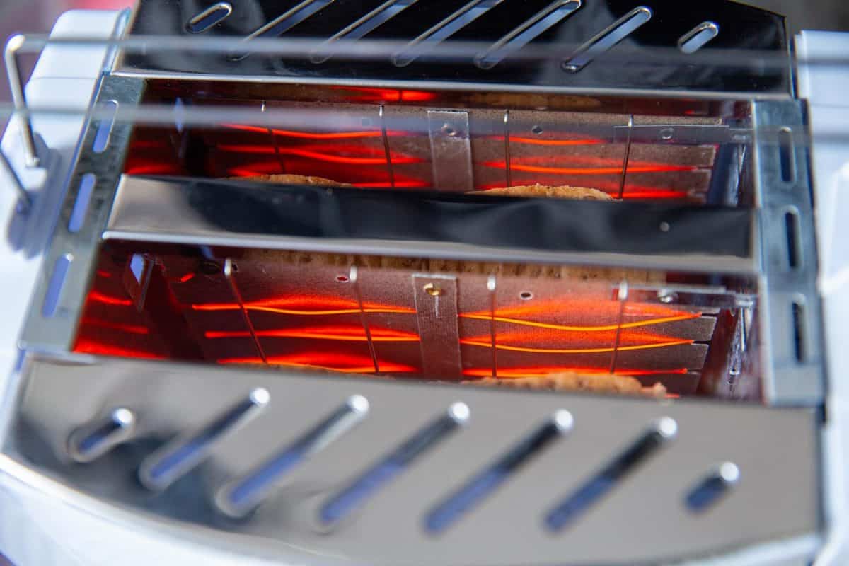 Closeup inside bread toaster heating element glowing red hot filament