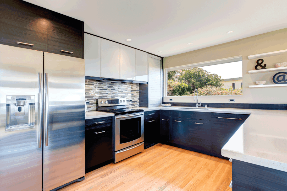 Elegant kitchen room with black wood storage combination accopmlished with stoned backsplash and decorative wall shelf