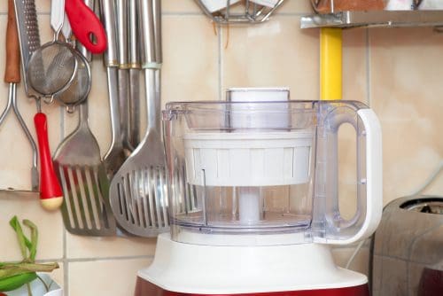 Food processor in the kitchen together with kitchen utensils
