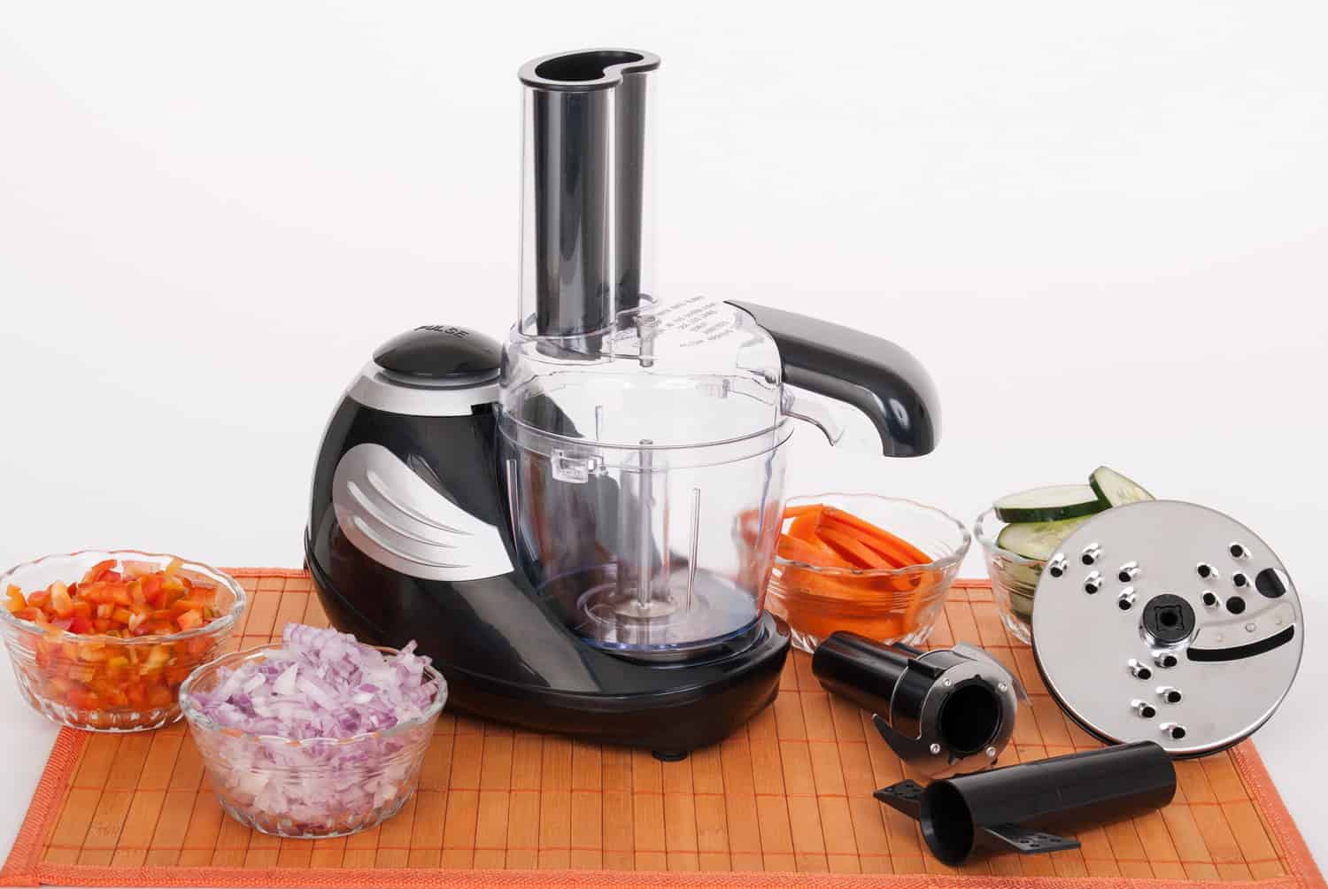 Food processor with accessories on white background.