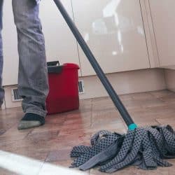 Low angle view of a man mopping the floor in his kitchen, How To Make Kitchen Floor Less Slippery [With 5 Simple Methods]